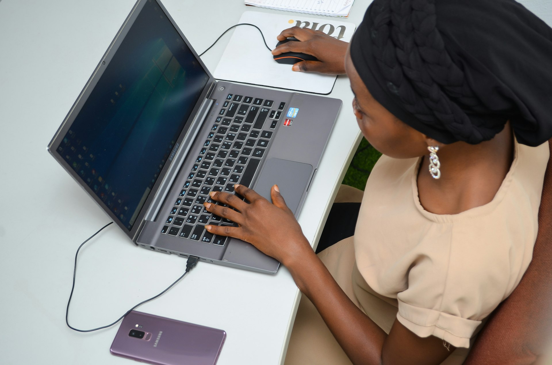 a woman sitting at a desk using a laptop computer